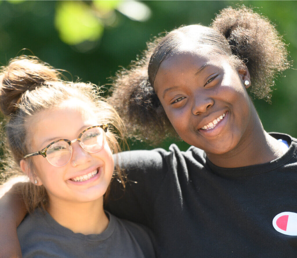 Two girls smiling together.