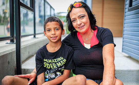Woman and child smiling and sitting together.